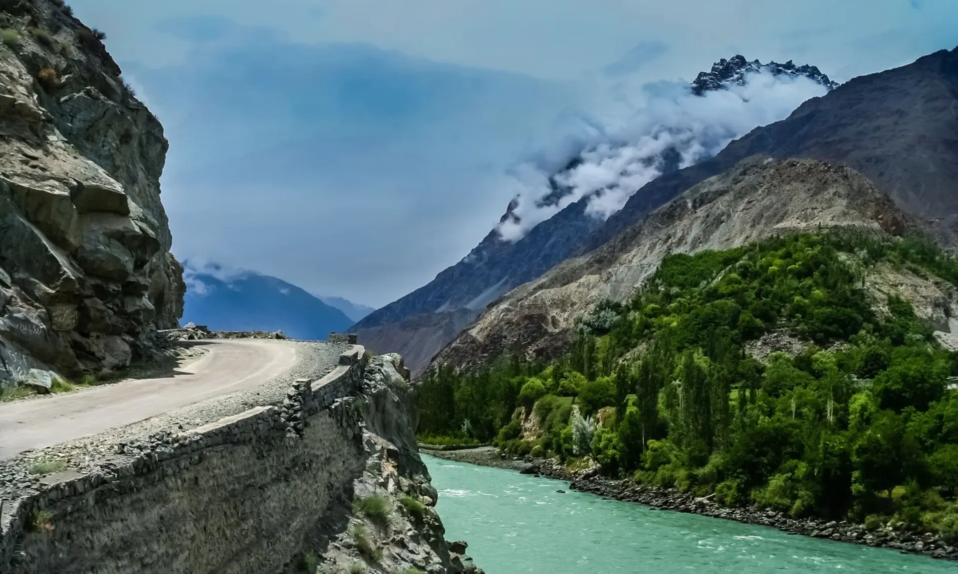 Mountain road above a turquoise river in Chitral, Pakistan