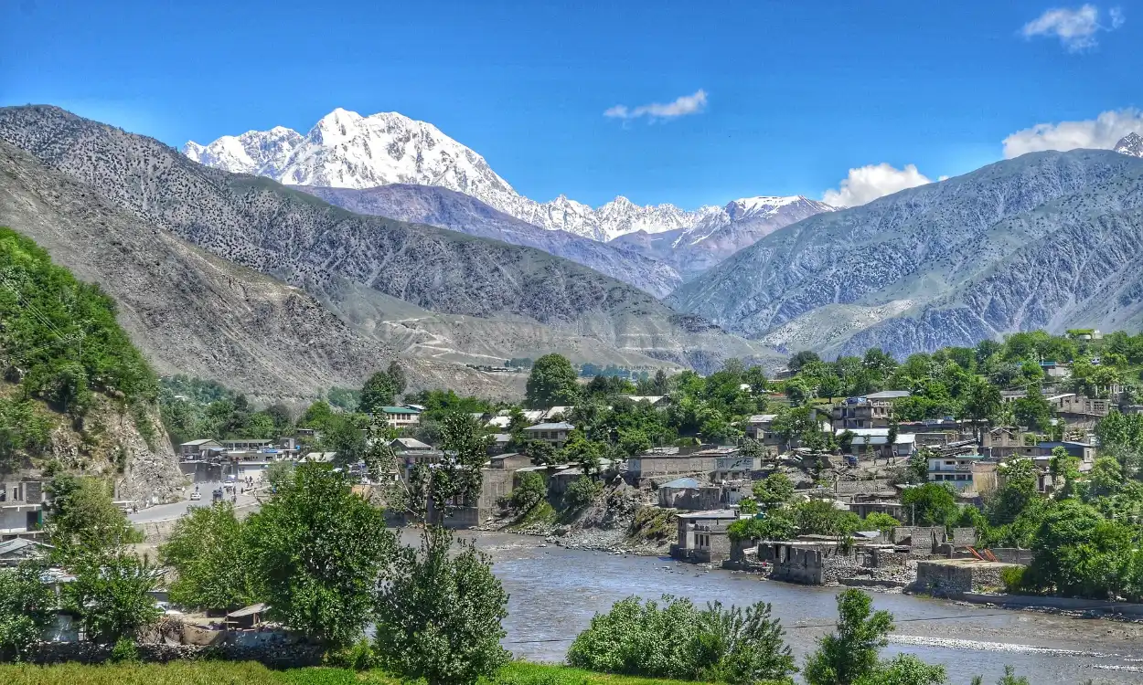 Chitral town and its river valley below the snowy summit of Tirich Mir, Pakistan