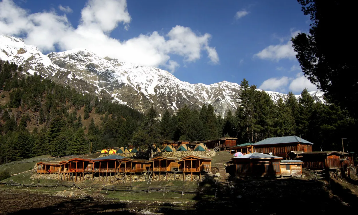 Wooden cottages on Fairy Meadows below snowy peaks, Gilgit-Baltistan, Pakistan