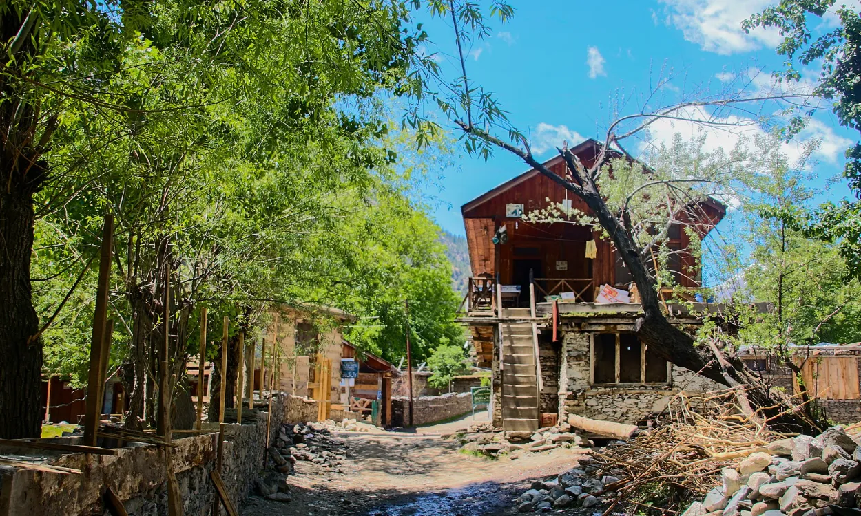 A traditional wooden house among green summer trees in Bumburet, Kalash Valley, Pakistan