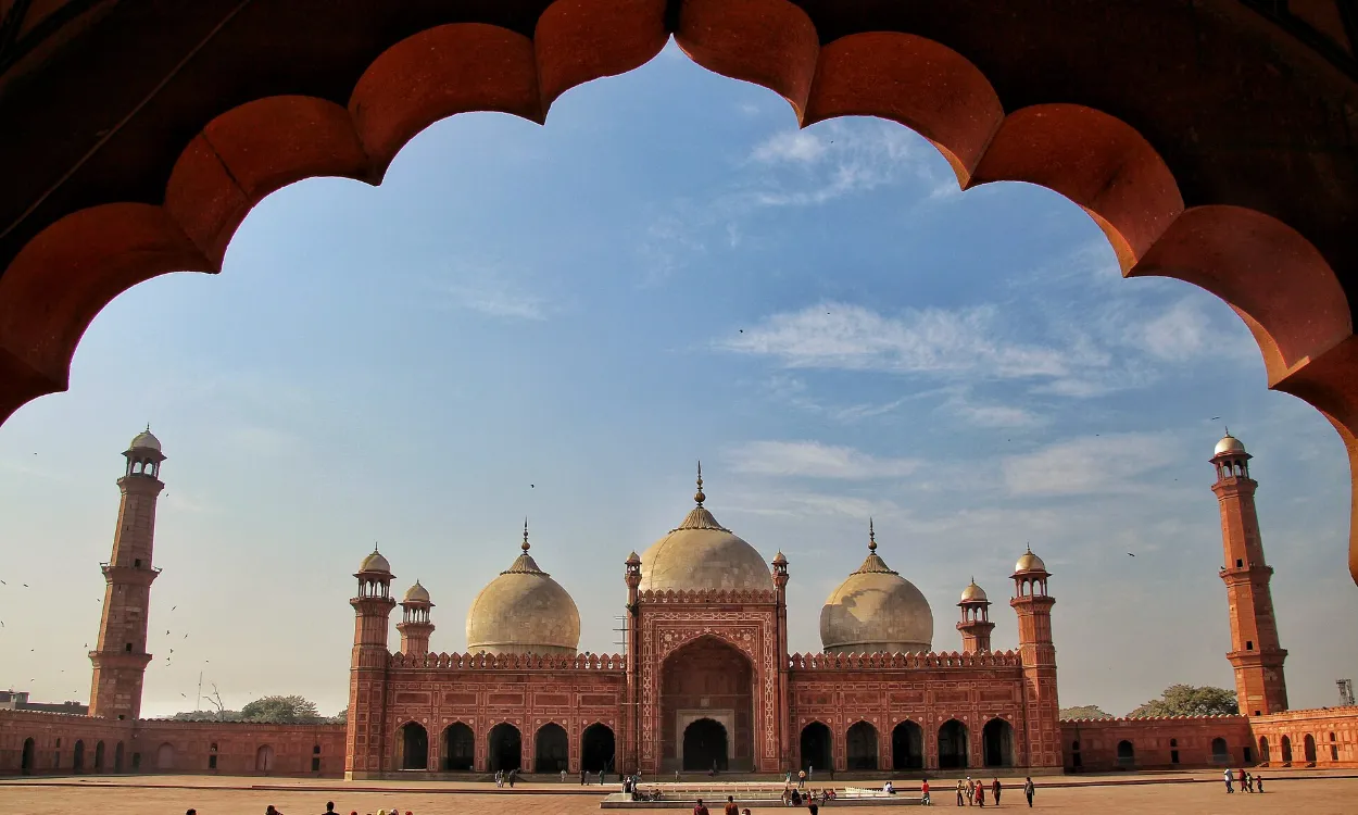 The Badshahi Mosque framed by a red sandstone arch in Lahore, Pakistan