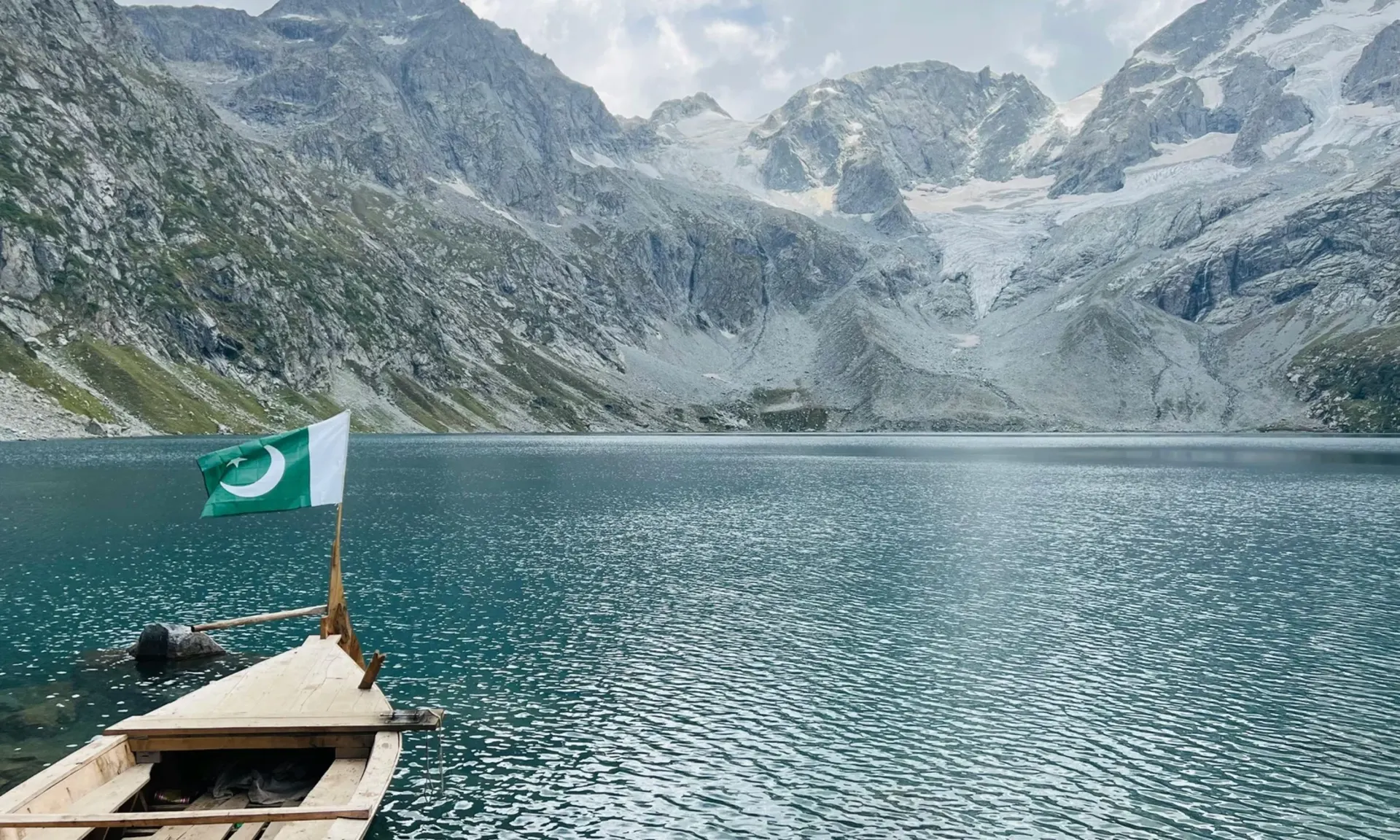 Boat with a Pakistan flag on a glacier lake in northern Pakistan