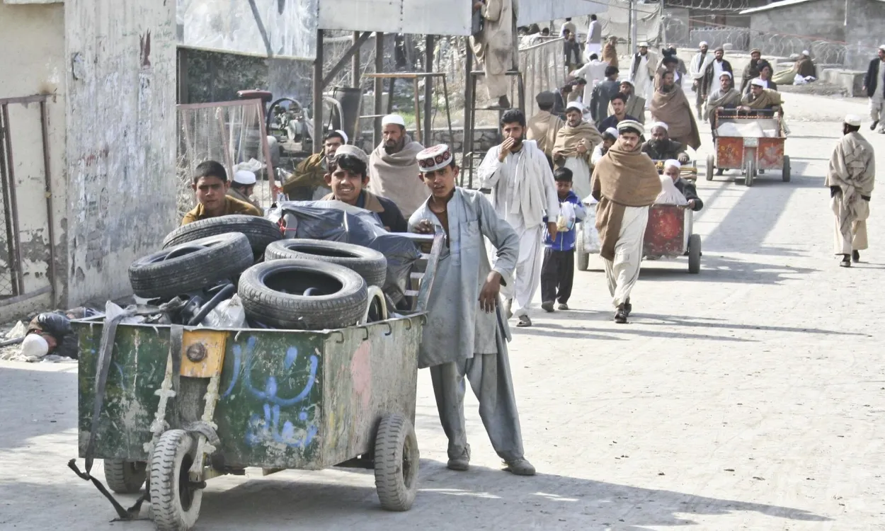 Travellers and carts at the Torkham border crossing in the Khyber Pass