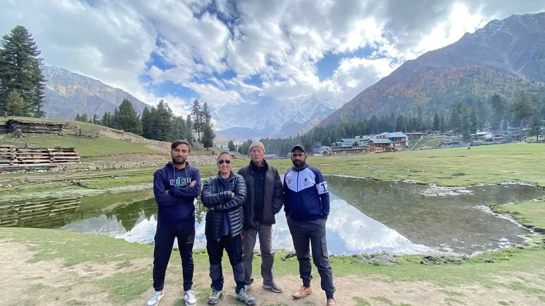 The Golden Adventure team with a traveller beside a lake at Fairy Meadows, Gilgit-Baltistan, Pakistan